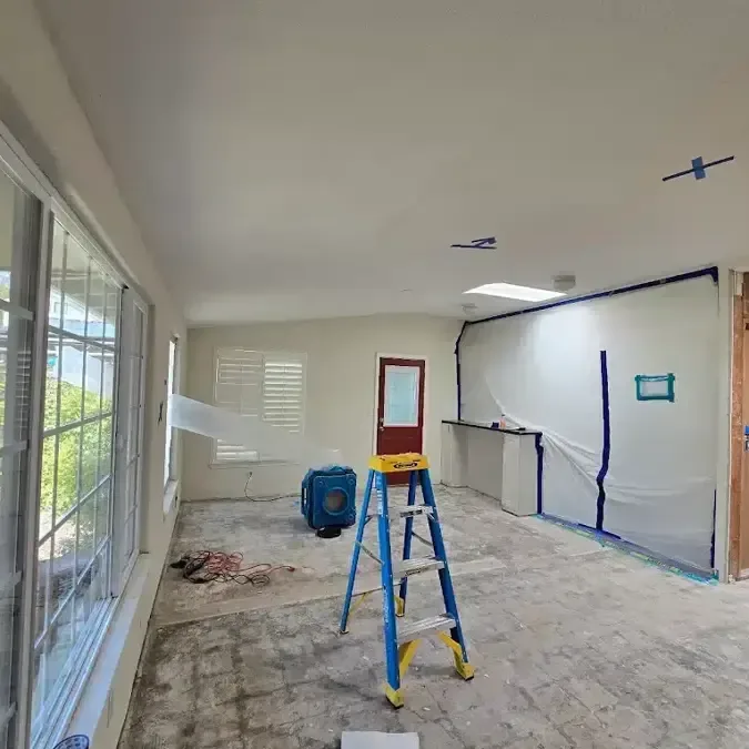 Plastic containment and a ladder in a room during restoration work