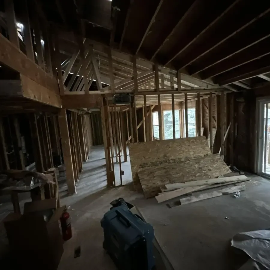 Exposed wall and ceiling framing with a dehumidifier on the subfloor