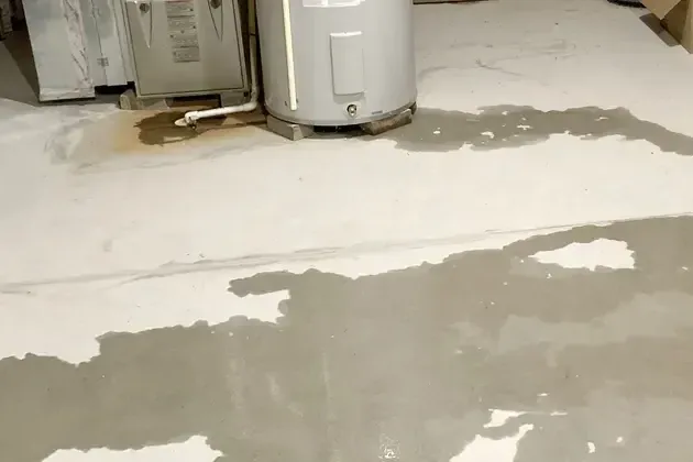 Pooled water on a garage floor beside a tank water heater